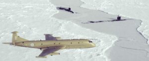 Shows a Nimrod Sopy Plane overflying two submaries surfaced in ICE